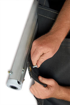Hands installing an aluminum tarp winder bar into a tarp edge, showing attachment hardware and rolled tarp material on a white background.
