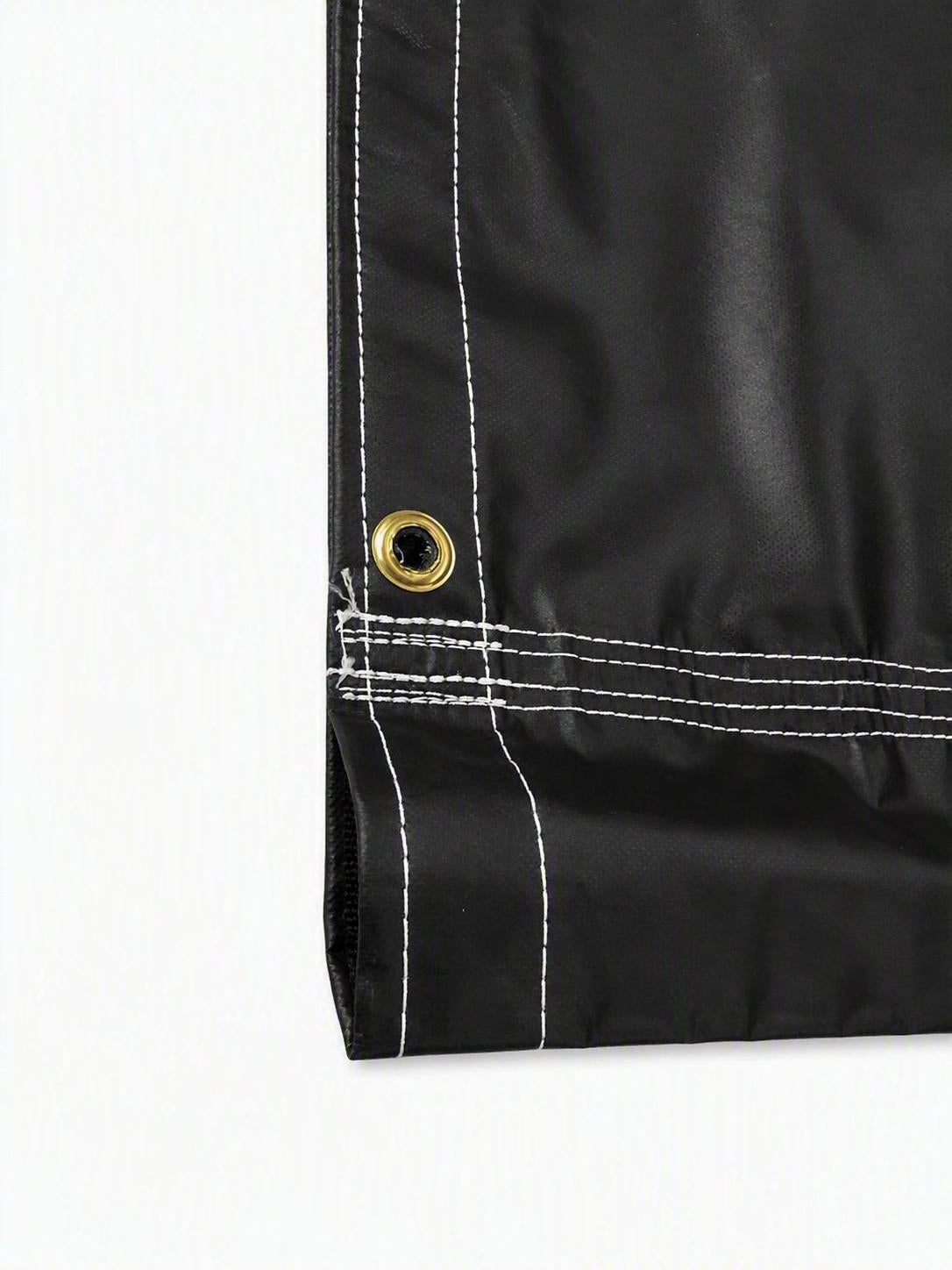 Close-up of a black waterproof fabric corner with white contrast stitching and a brass grommet on a white background.
