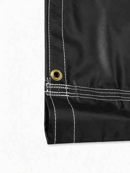 Close-up of a black waterproof fabric corner with white contrast stitching and a brass grommet on a white background.